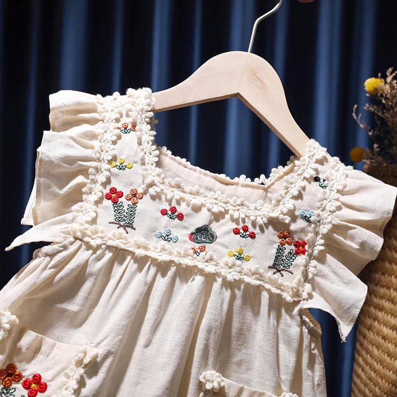 Hermoso vestido sin mangas de verano para niñas, en algodón blanco crudo, bordado con flores de colores, estilo vintage, con vuelo en terminación del ruedo para dar más soltura