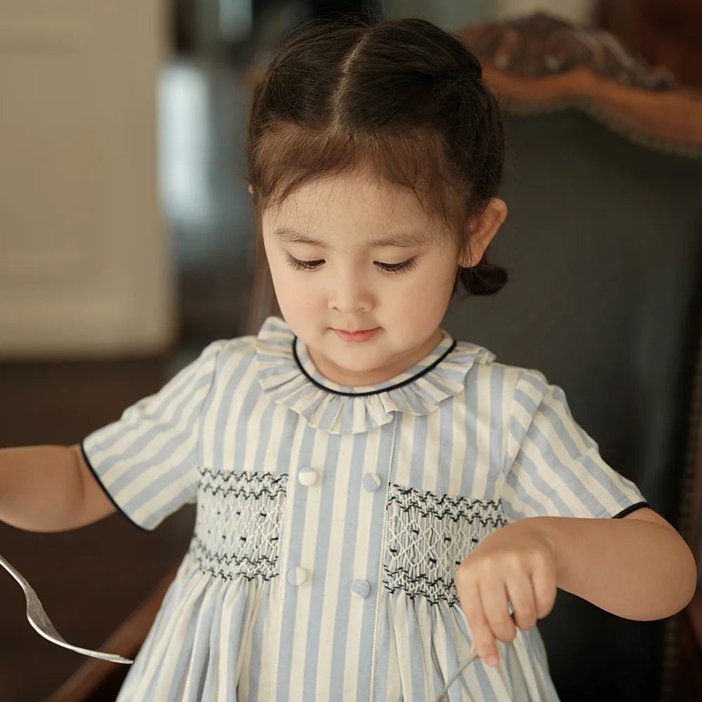 Vestido para niña, estilo moda española de alta gama, bordado punto smock y botones sobre rayas, ribete azul marino, traje de algodón de manga corta, para vacaciones de primavera y verano